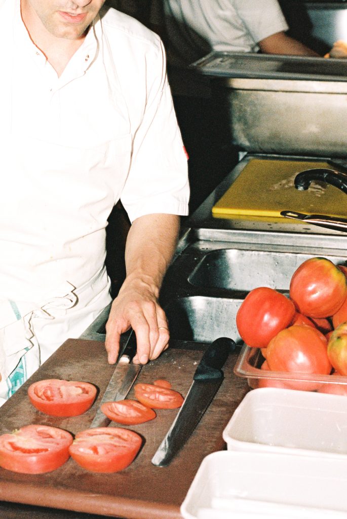 Chef in the kitchen preparing heritage tomatoes.